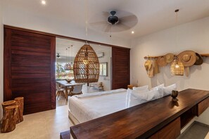 Une chambre à coucher avec un lit, une table de chevet et un ventilateur de plafond.