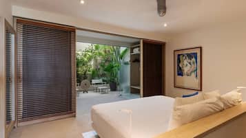 Une chambre moderne avec un grand lit, un banc en bois et une vue sur un jardin extérieur.