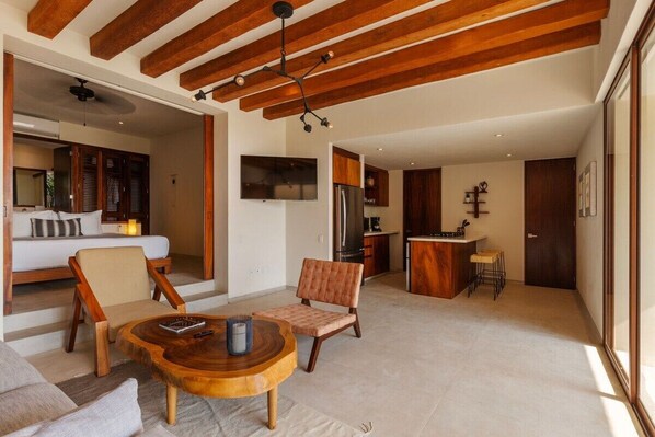 A modern living area with a wooden ceiling, a round coffee table, and seating.