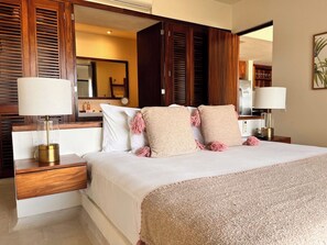 A hotel bedroom with a large bed, wooden headboard, bedside tables, and a mirror. - Zihua 4BR Villa • Luxury Stay w/ Pool & Views (Zihuatanejo)