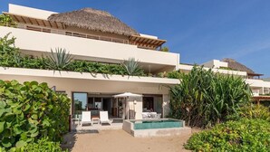 A modern resort with a pool, outdoor seating, and lush landscaping. - Beachfront 3BR Villa I Private Pool + Sand Access (Zihuatanejo)