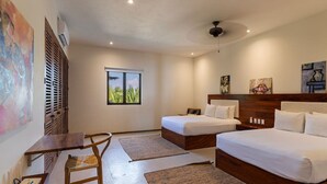 A hotel room with a bed, a desk, and a chair. There is a window with a view of palm trees. - Zihuatanejo 3BR • Sunset Views, Pool + Beach Acces (Zihuatanejo)