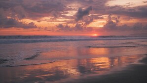 Una platja al capvespre amb onades i núvols.