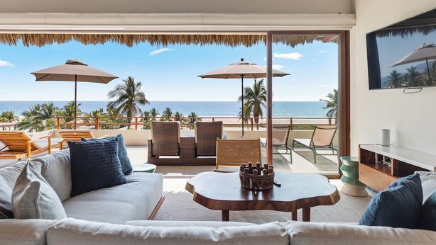 A room with a view of the beach, furnished with a sofa, chairs, and a table. - 4BR Villa Playa Blanca – Infinity Views & Comfort (Zihuatanejo)