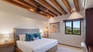 A bedroom with a large bed, wooden beams, a window with a view, and a wall-mounted artwork. - 4BR Villa Playa Blanca – Infinity Views & Comfort (Zihuatanejo)