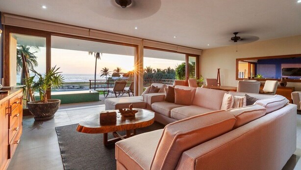 A modern living room with a sofa, coffee table, and a view of the ocean. - 3BR Villa I Breathtaking Ocean Views + Terrace (Zihuatanejo)