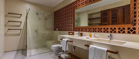 A modern bathroom with a glass shower enclosure, a white toilet, a vanity with a mirror, and a wooden floor.