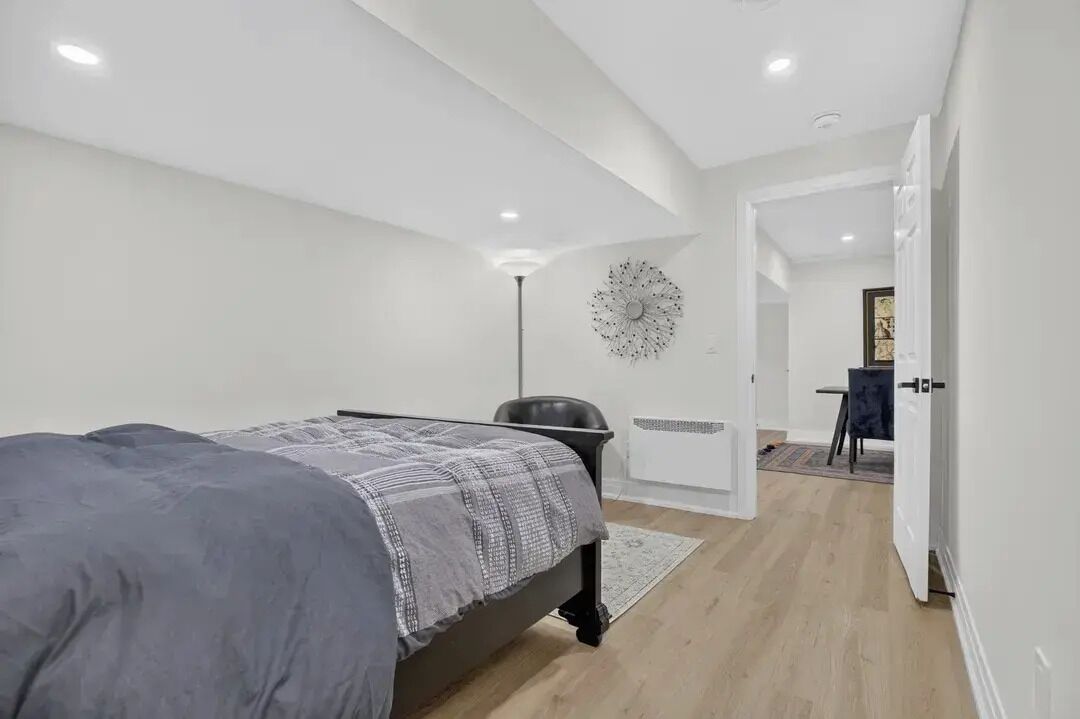 A bedroom with a bed, a desk, and a chair.