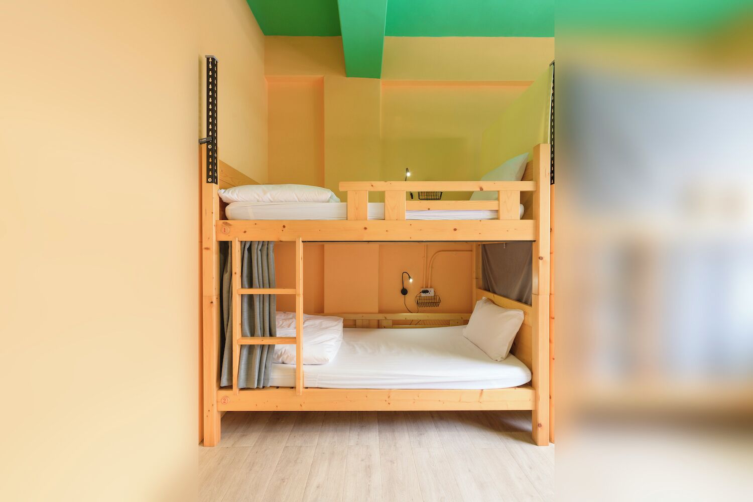 A bunk bed room with a ladder, a desk, and a chair.