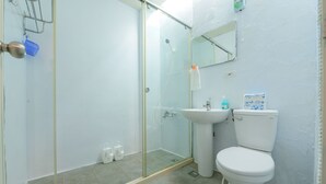A bathroom with a glass shower enclosure, a sink, and a toilet. - Dumbo Hostel Hualien (Hualien City)