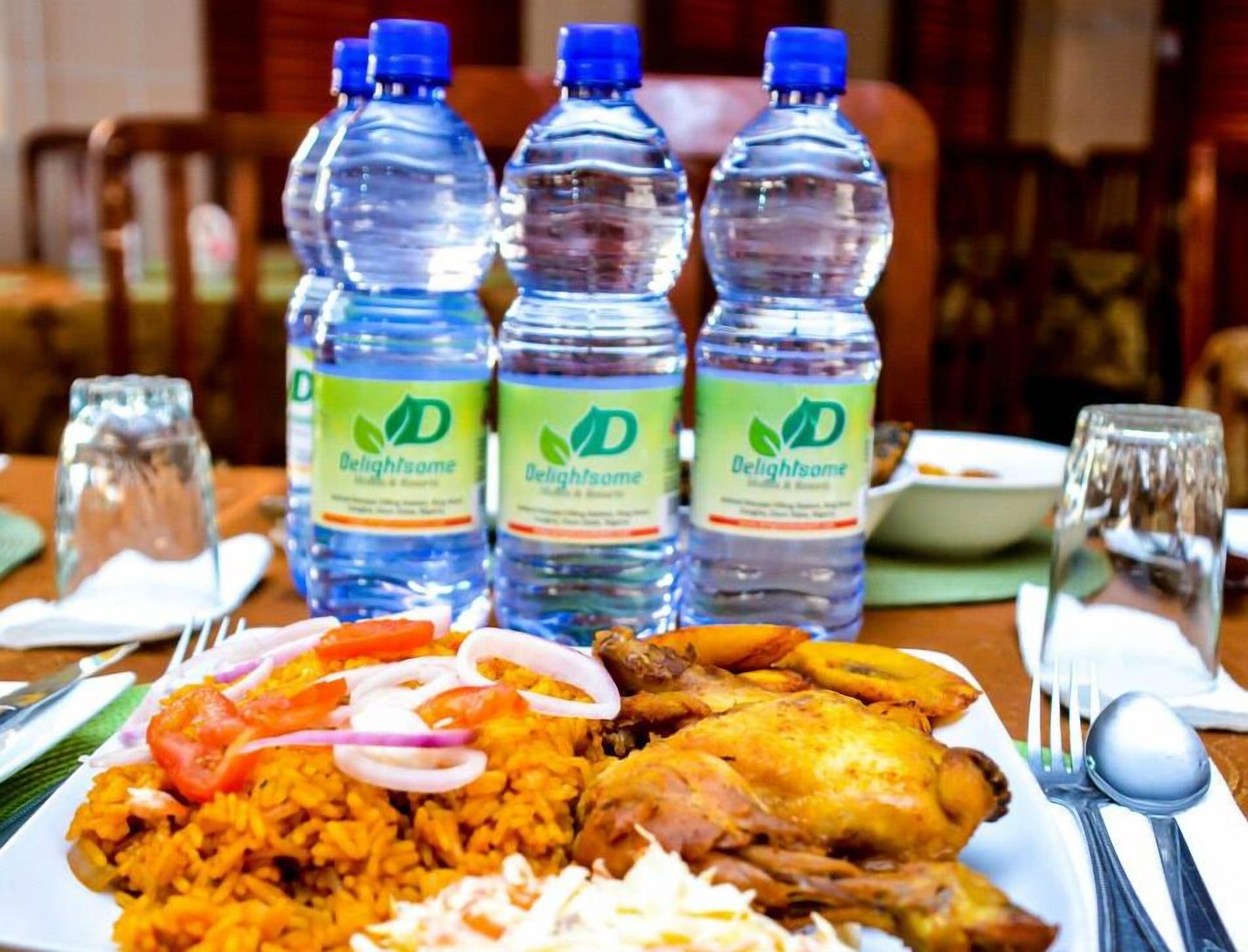 A plate of food with a bottle of water.