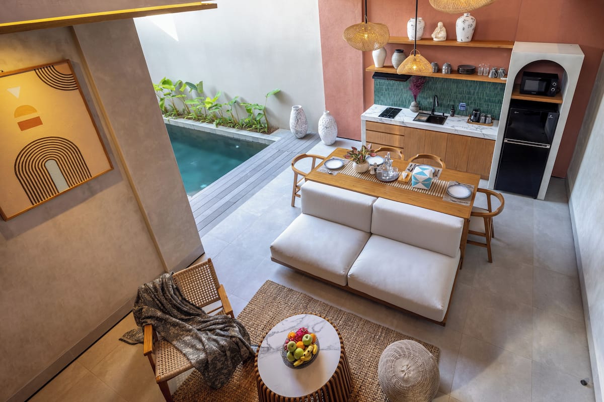 A compact living space with a kitchen, dining area, and a small pool.