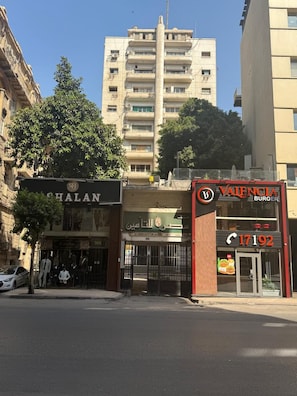 Vista de la calle con un edificio que muestra un letrero que dice 'Valencia Burgers' y otro letrero que dice 'Shalan'.