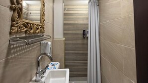 A compact bathroom with a white sink, a toilet, and a shower curtain. - Ambiance Downtown Hotel (Cairo)