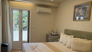 A hotel room with a large bed, a small desk, an air conditioner, a picture on the wall, and a view through the door. - Ambiance Downtown Hotel (Cairo)