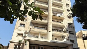 A multi-story building with a central column, a ground-level entrance, and a staircase leading up to the entrance. - Ambiance Downtown Hotel (Cairo)