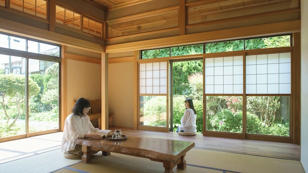 A traditional Japanese room with tatami flooring, a low wooden table, and sliding doors with a view of greenery outside. - Ichi to Koji (Gojome)