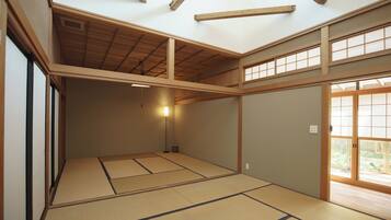 A traditional Japanese room with tatami flooring, wooden beams, and sliding doors.