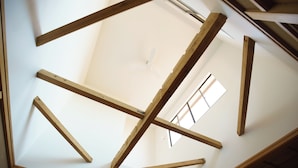 A room with a high ceiling, wooden beams, and a skylight. - Ichi to Koji (Gojome)