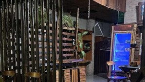 A rustic interior with wooden furniture, a stage, and a seating area. - Casarao24horas (Cuiabá)