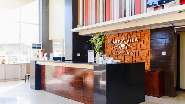 A reception desk with a wooden panel design and the name "EAST VIEW HOTEL" above it. - EAST VIEW HOTEL (Bacolod)