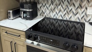 A kitchen with a microwave, toaster, coffee maker, and stove. - Amazing Home Away From Home (Valdosta)