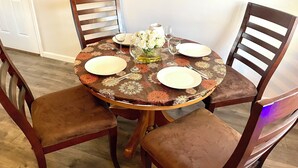 A dining table set with plates, cutlery, and a vase of flowers.