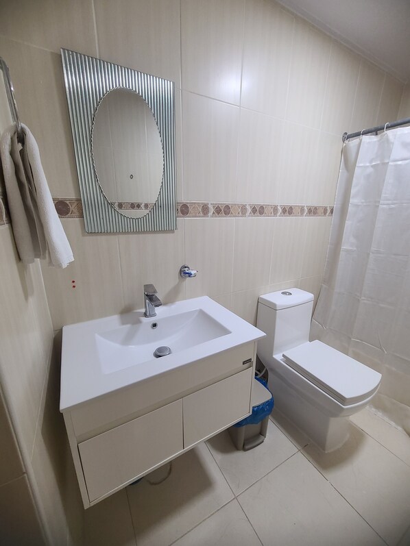 Ein Badezimmer mit einem weißen Waschbecken, einer Toilette und einer Duschvorhang.