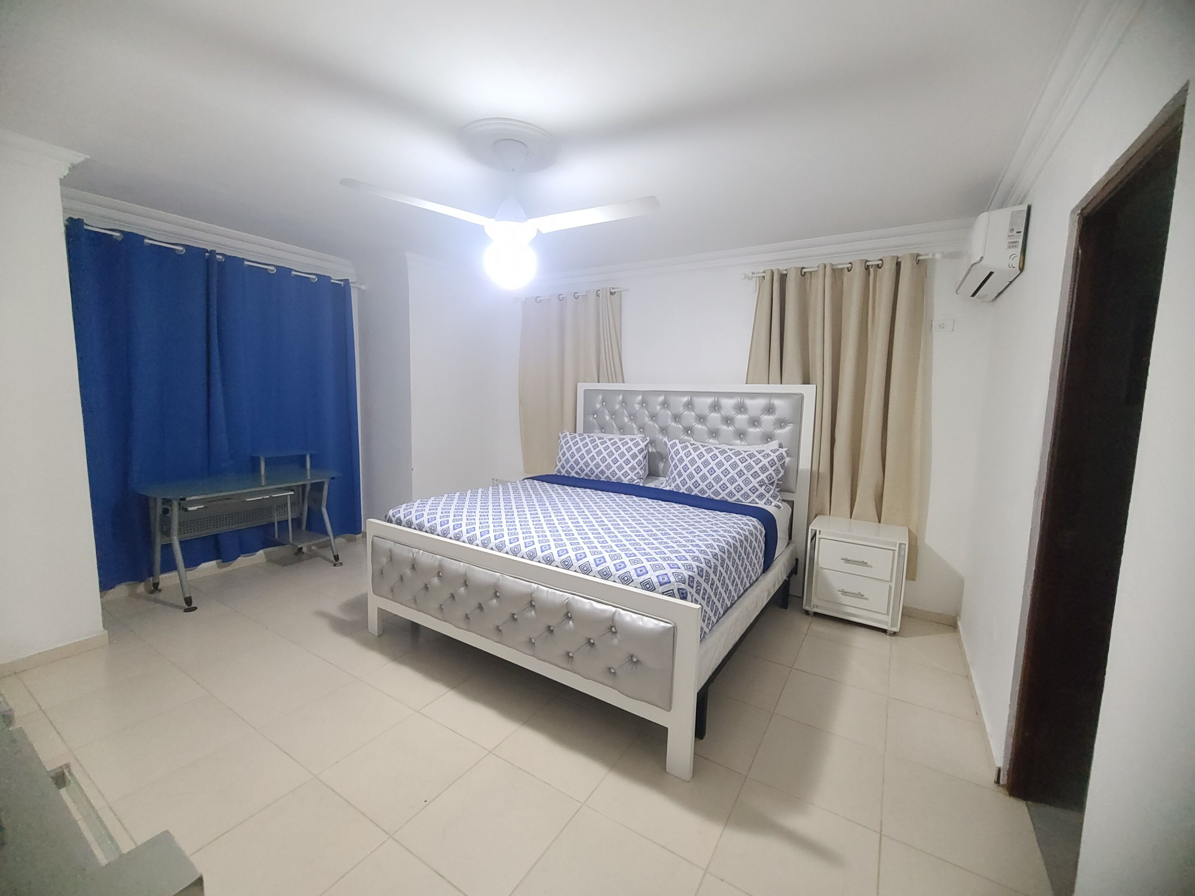 Un dormitorio con cama, escritorio y silla.