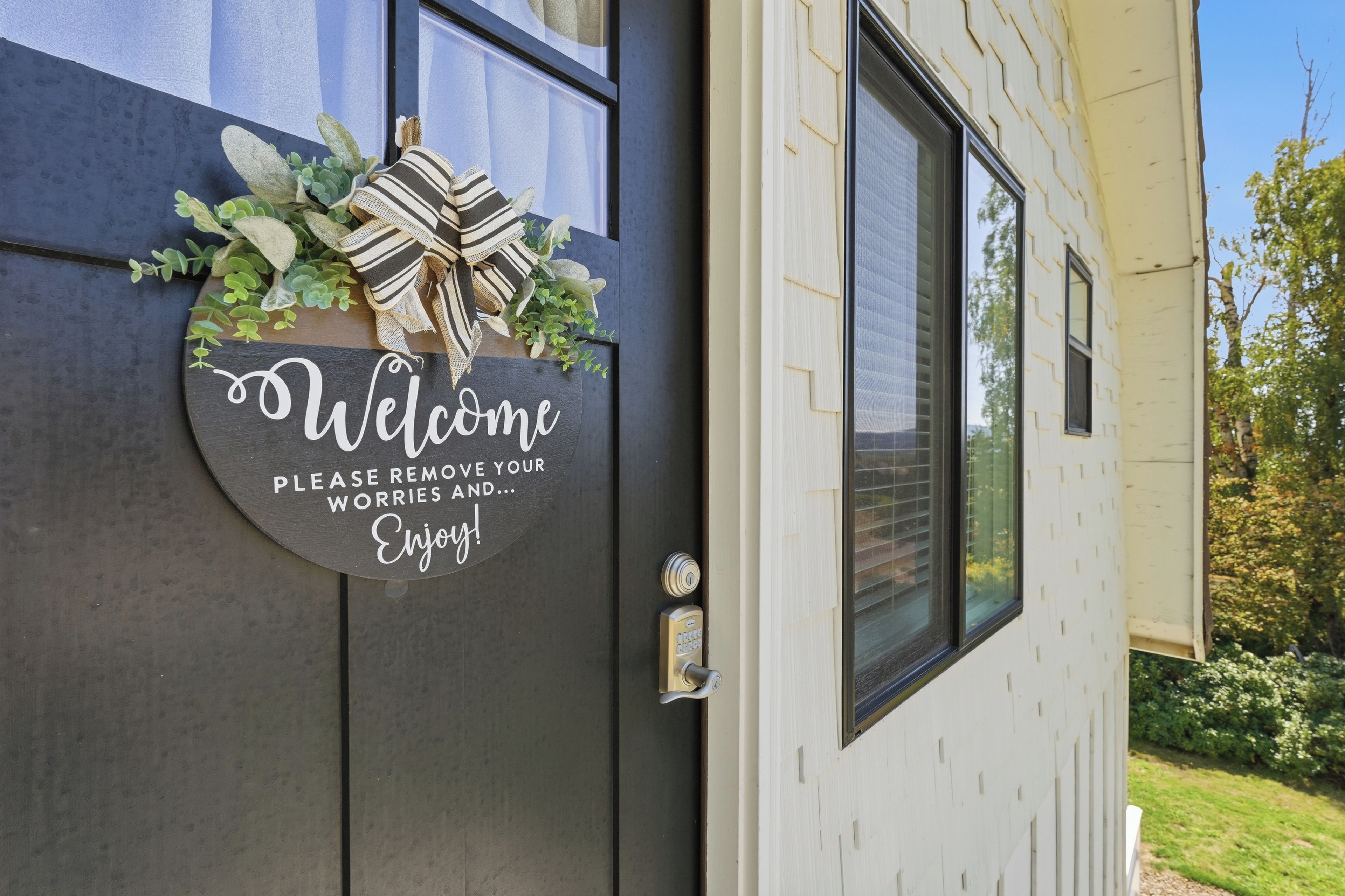 A welcome sign with a message on a door, a window, and a doorbell.
