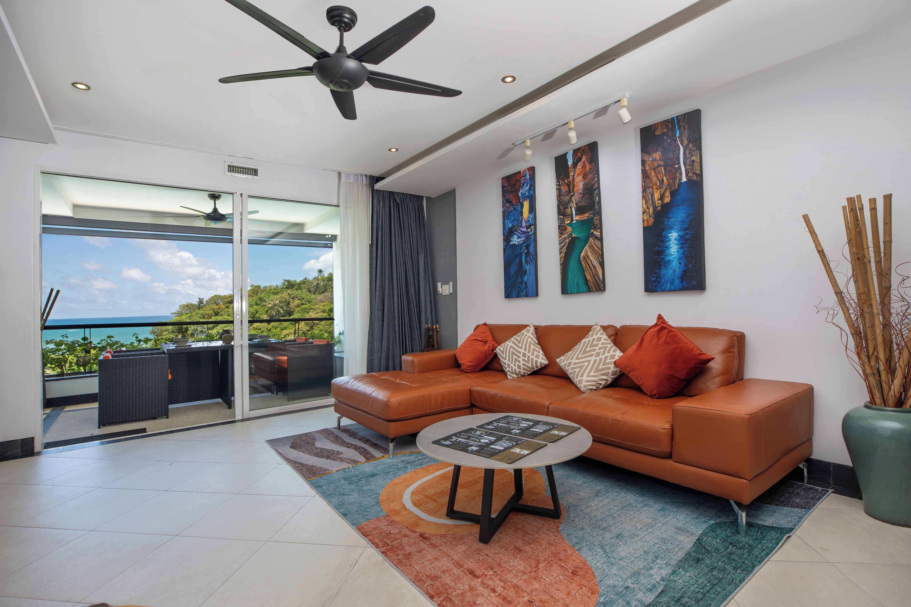A modern living room with a leather sofa, a coffee table, and artwork on the wall.