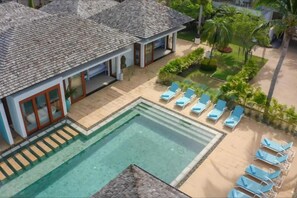 Een modern resort met een zwembad, ligbedden en een keurig onderhouden tuin.