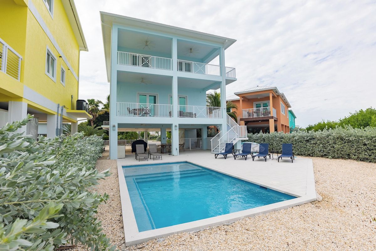 A two-story building with a swimming pool and outdoor seating.