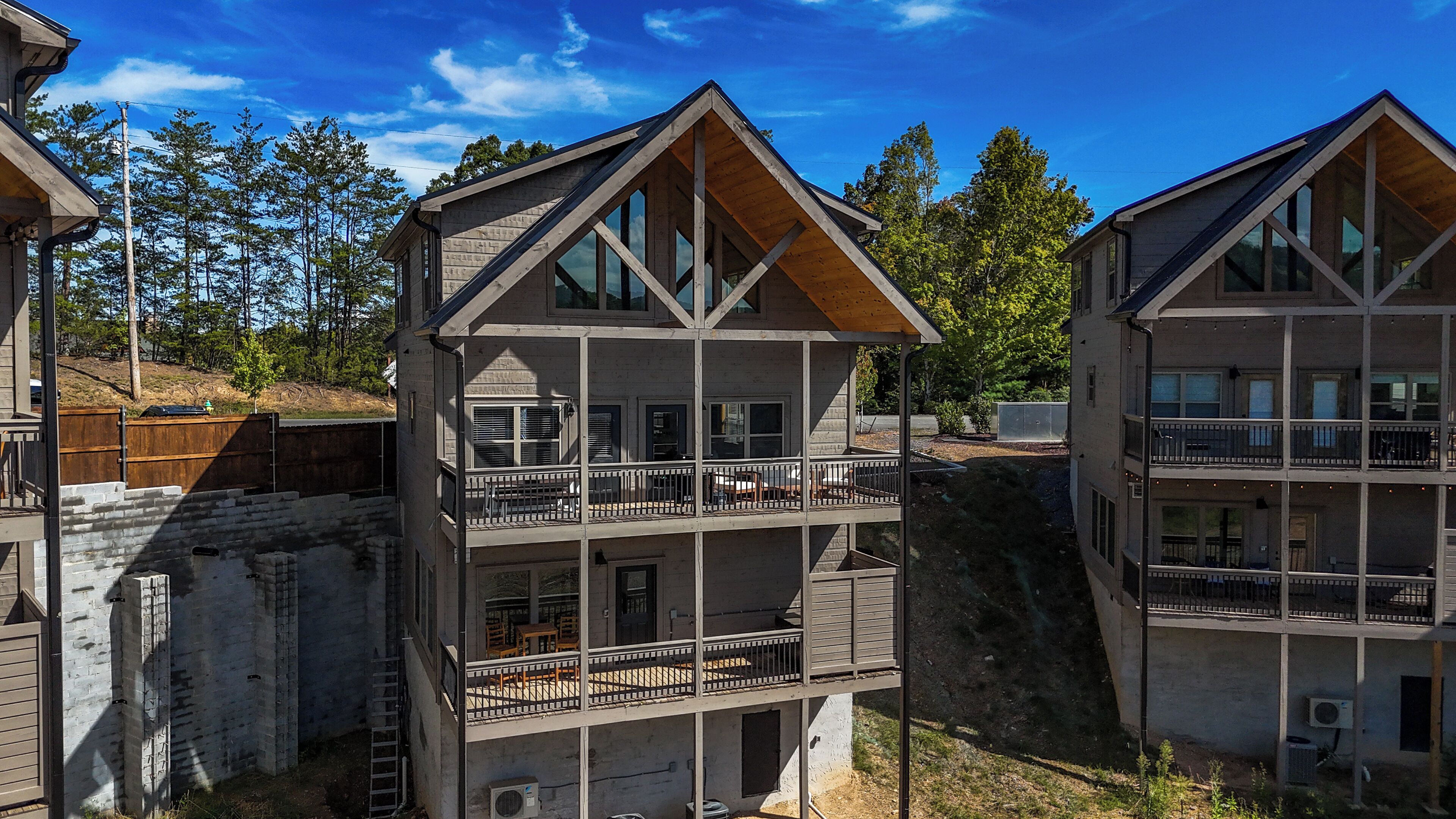 A multi-story building with balconies, large windows, and a wooden facade.