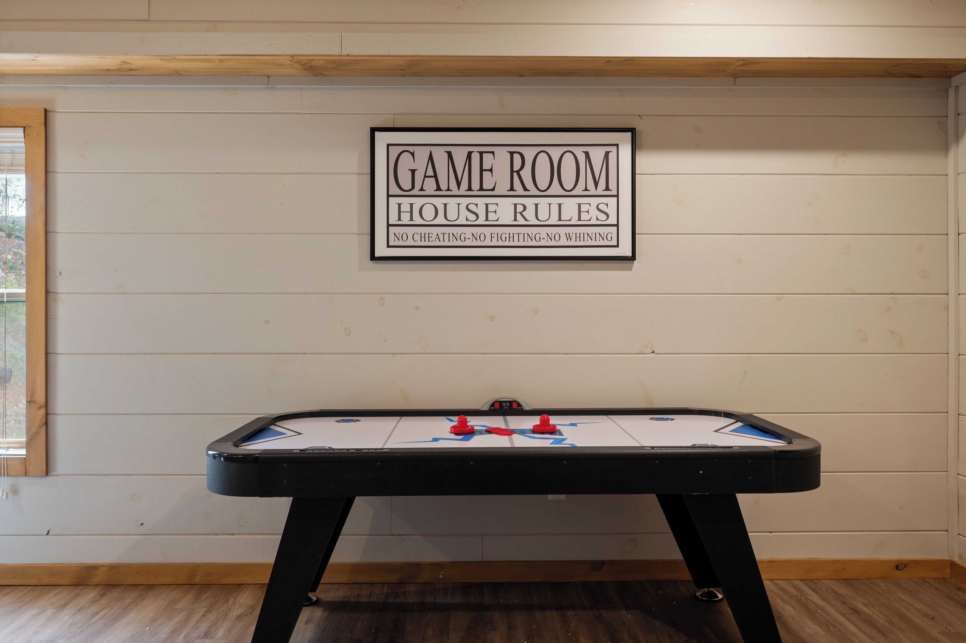 Een speelkamer met een tafelvoetbaltafel en een bord waarop staat: 'GELDENDE SPEELREGELS GEEN FRAUDE - GEEN RUZIES - GEEN GEMEENDOENIGHEID'.