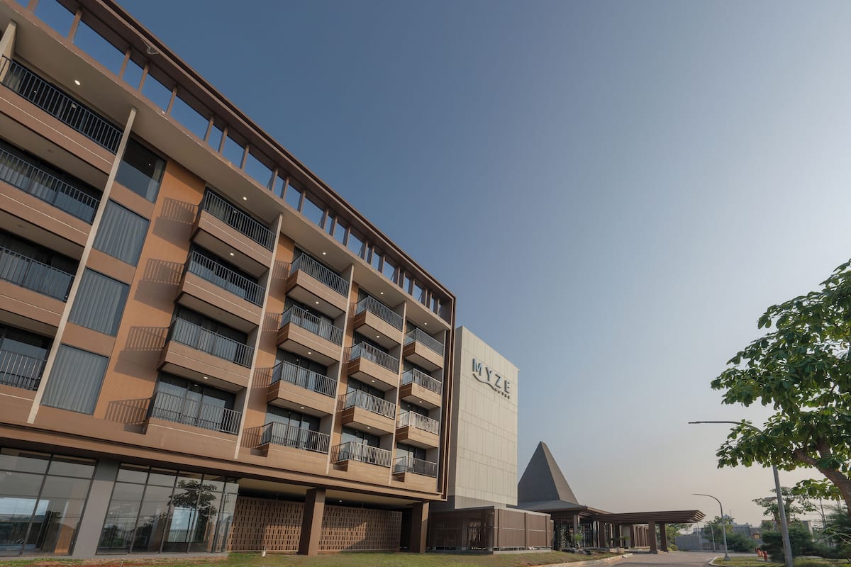 A modern hotel building with multiple balconies and a prominent entrance.