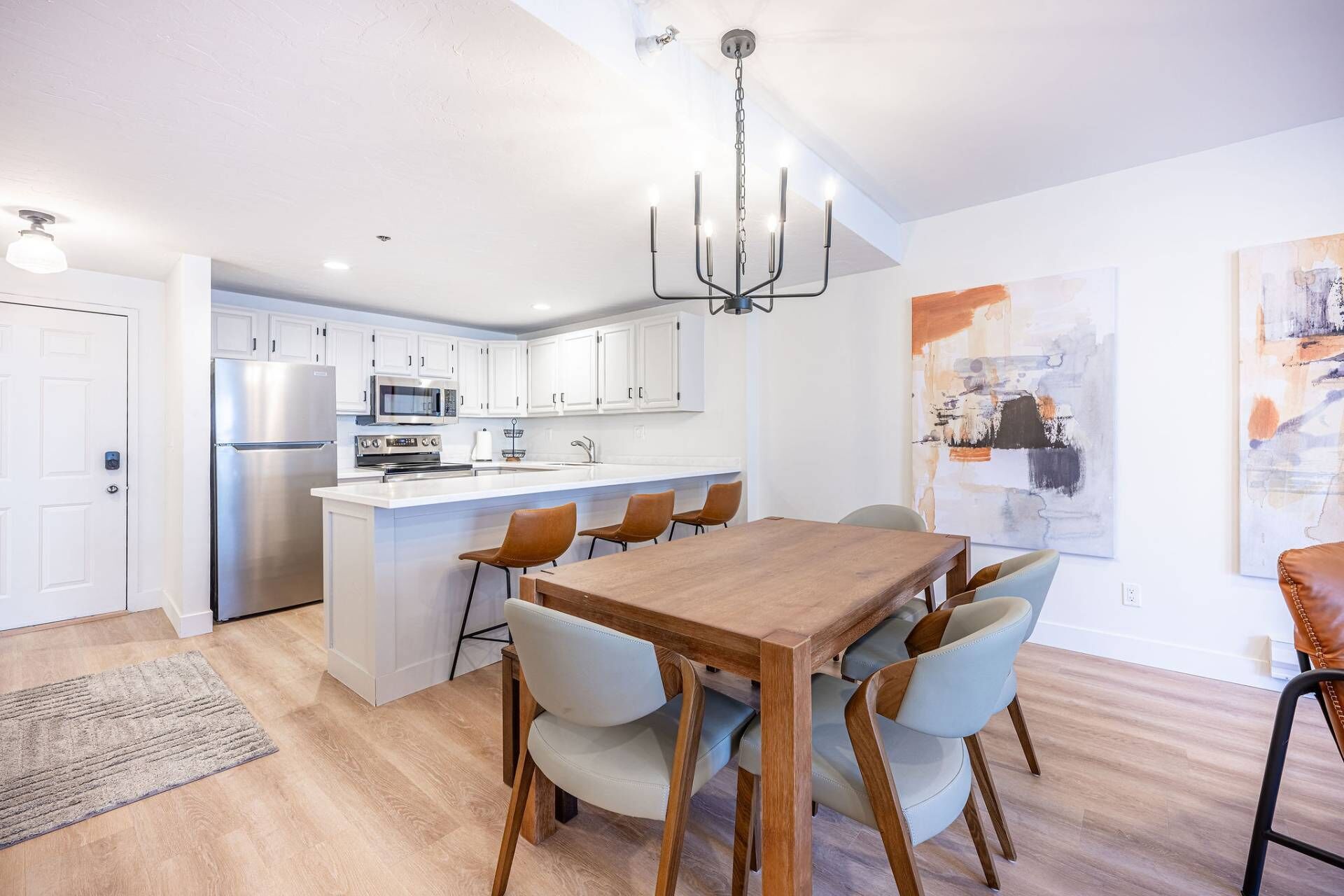A modern kitchen with white cabinets, stainless steel appliances, and a central island with seating.