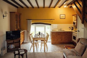 Un salon confortable avec un téléviseur, des meubles en bois et un canapé.