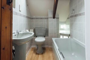 Une salle de bain avec un lavabo, des toilettes et une baignoire.