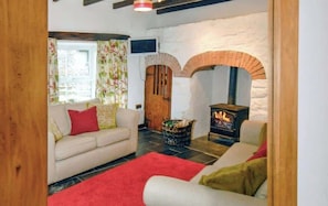 A cozy living room with a fireplace, a sofa, and a television. - Cosy Stone Cottage w/ Log Burner & Views (Nolton)