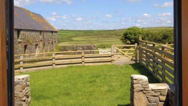A stone building with a wooden fence and a grassy area in front. - Cosy Stone Cottage w/ Log Burner & Views (Nolton)