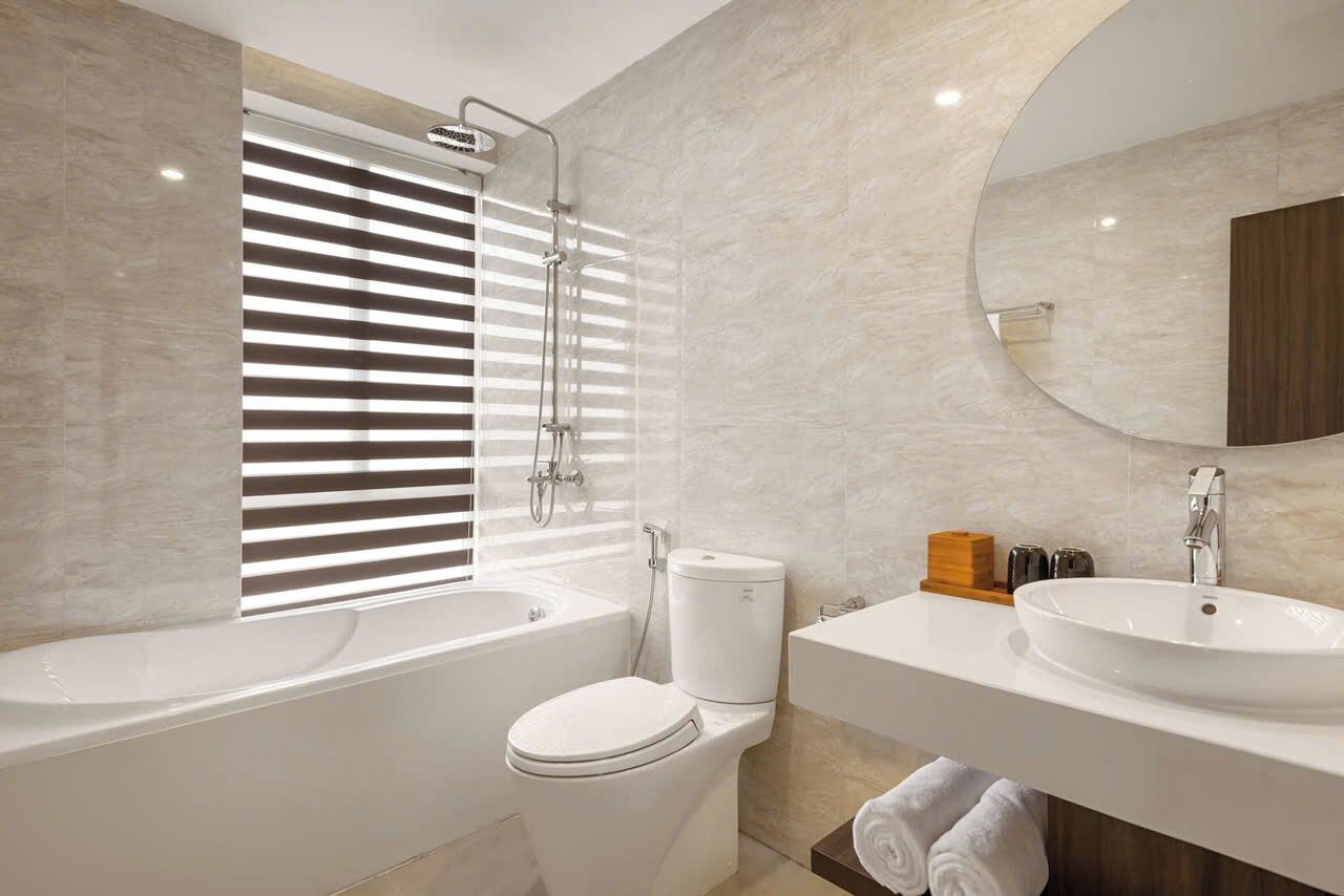 Ein modernes Badezimmer mit Badewanne, Toilette und zwei Waschbecken.