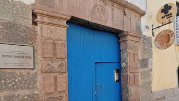 Una puerta azul con una placa en la pared a su izquierda.
