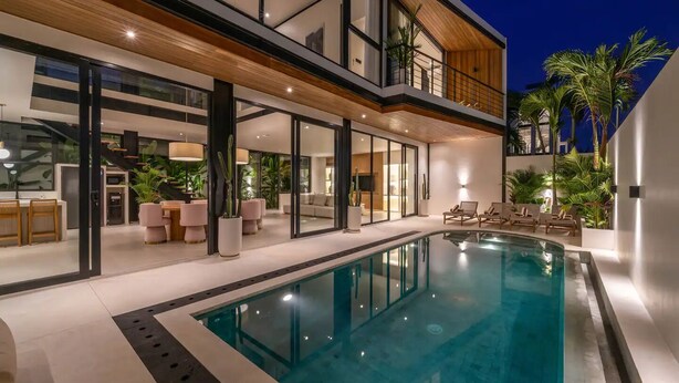 A modern house with a large swimming pool, outdoor seating, and a balcony. - Villa Maverick (Canggu)