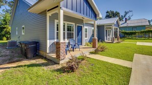 A two-story house with a covered porch, a front door, and a small garden area with a lawn and a pathway. - 1 Mi to Florida State University: Tallahassee Gem (Tallahassee)