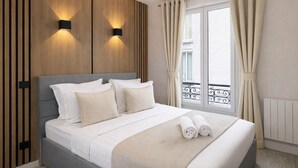 A hotel room with a bed, two wall-mounted lights, a window with curtains, and a balcony railing.
