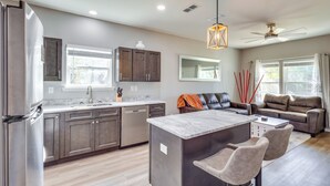 A modern kitchen with a central island, dark cabinets, and a stainless steel refrigerator. - 1 Mi to Florida State Capitol: Tallahassee Escape (Tallahassee)
