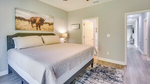 A bedroom with a bed, a ceiling fan, a rug, and a painting of cattle. - 1 Mi to Florida State Capitol: Tallahassee Escape (Tallahassee)