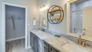 A modern bathroom with a large mirror, a vanity with a sink, and a shower area. - 1 Mi to Florida State Capitol: Tallahassee Escape (Tallahassee)