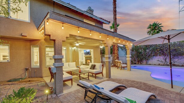 A covered outdoor area with lounge chairs, a pool, and a patio with a view of the pool. - The Blue Lagoon: Where Space, Style and Comfort collide! (Las Vegas)